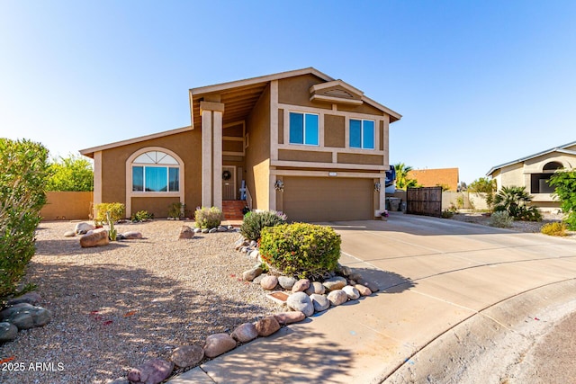 view of front of house featuring stucco siding, concrete driveway, an attached garage, and fence