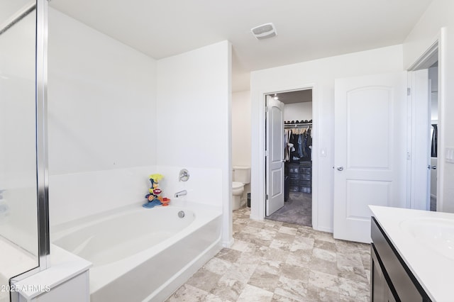 bathroom with a tub, toilet, and vanity