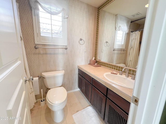 bathroom featuring a healthy amount of sunlight, tile patterned flooring, toilet, and wallpapered walls