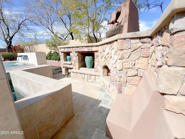 view of patio / terrace featuring a fireplace, fence, and a fenced in pool