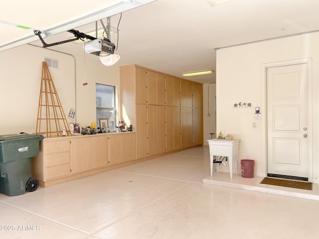 garage featuring a garage door opener and visible vents