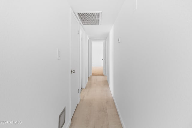 corridor with light hardwood / wood-style floors