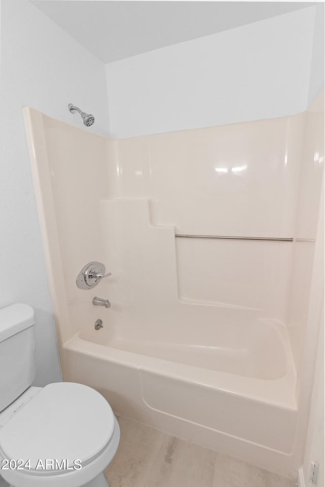 bathroom with tile patterned flooring, bathtub / shower combination, and toilet