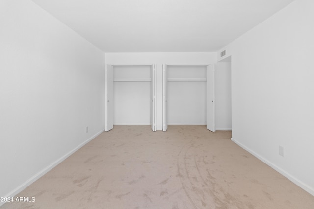 unfurnished bedroom featuring light carpet