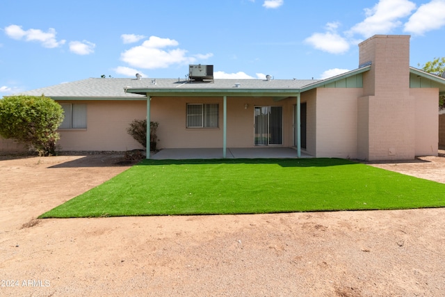 rear view of house featuring cooling unit, a yard, and a patio area