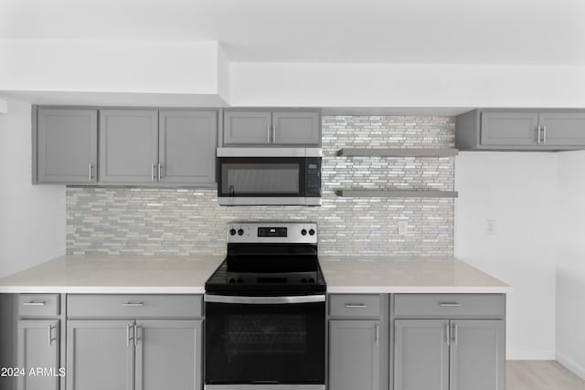 kitchen featuring gray cabinets, tasteful backsplash, and appliances with stainless steel finishes