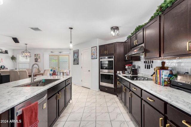 kitchen featuring decorative light fixtures, dark brown cabinets, sink, and stainless steel appliances