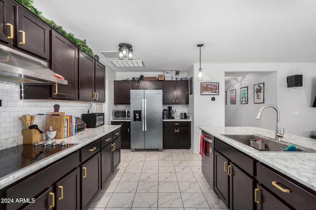 kitchen featuring dark brown cabinetry, extractor fan, sink, black appliances, and hanging light fixtures