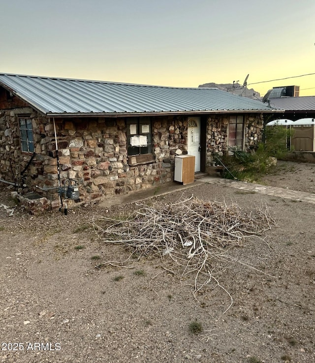 829 W Spray St, Superior, AZ 85173 - property exterior at dusk with stone siding and metal roof