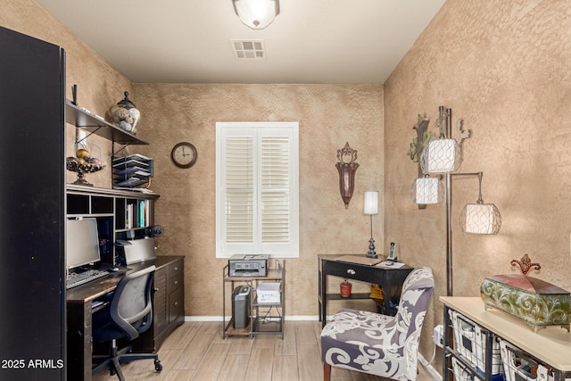 office featuring wood tiled floor, visible vents, and baseboards