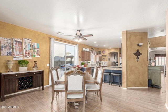 dining room featuring ceiling fan, visible vents, baseboards, and wood finish floors