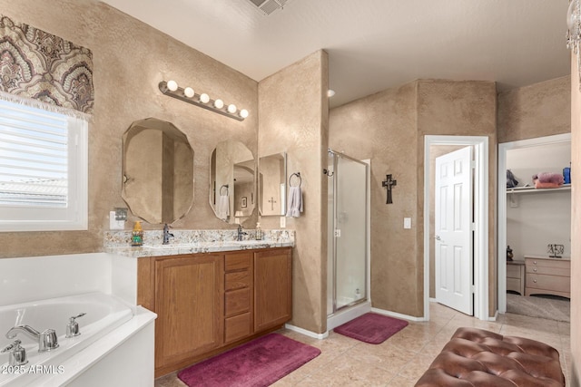 bathroom featuring a garden tub, tile patterned flooring, a shower stall, and vanity