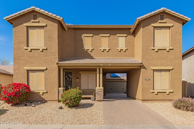 view of front of home with a tile roof, decorative driveway, and stucco siding