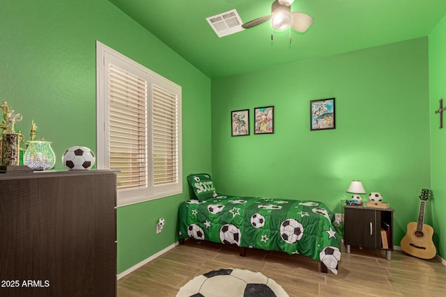 bedroom featuring wood finish floors, visible vents, ceiling fan, and baseboards