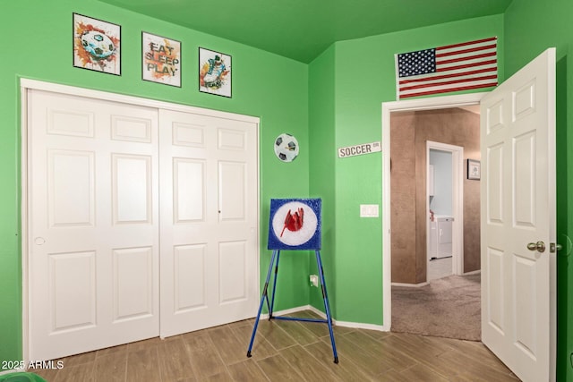 game room with washer / clothes dryer, wood finished floors, and baseboards