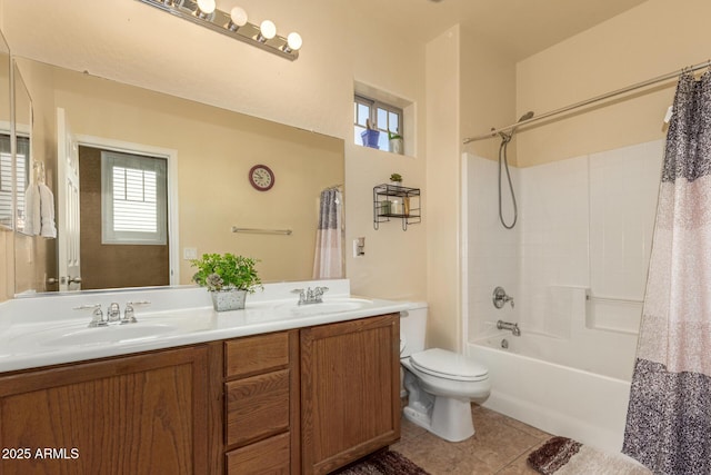 bathroom with double vanity, a sink, toilet, and tile patterned floors