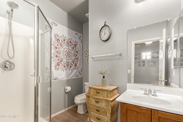 full bath featuring toilet, a stall shower, wood finished floors, and vanity