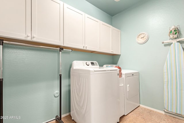 laundry area with cabinet space, light tile patterned floors, baseboards, and independent washer and dryer