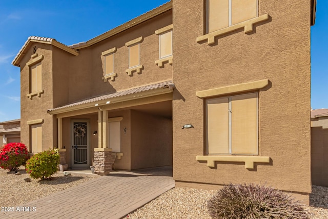 view of front of home featuring a tiled roof and stucco siding