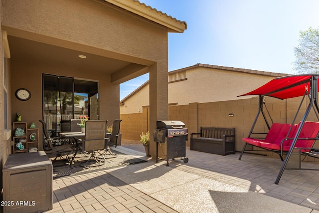 view of patio / terrace with a grill, fence, and outdoor dining area