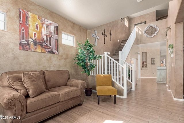 living room with stairway, baseboards, and wood finished floors