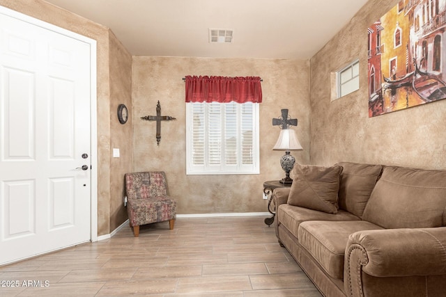 living room with baseboards, visible vents, and wood tiled floor