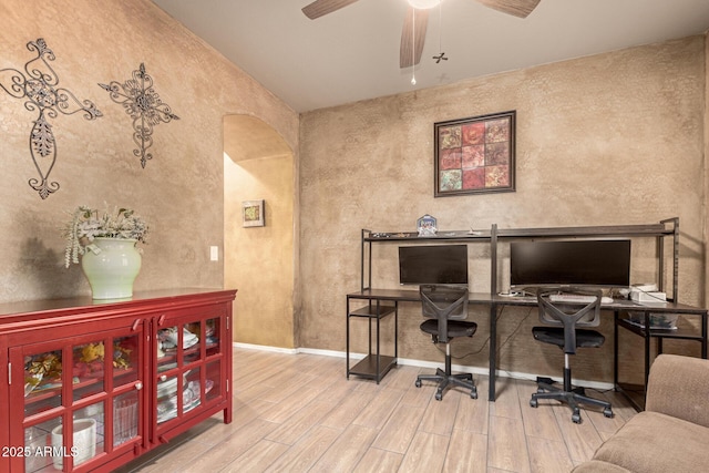 office space featuring a ceiling fan, baseboards, and wood finished floors