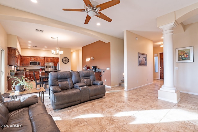 living room featuring sink, ceiling fan with notable chandelier, and decorative columns