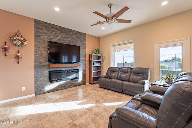 living room featuring ceiling fan, a fireplace, and plenty of natural light