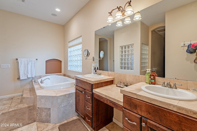 bathroom featuring vanity, a relaxing tiled tub, and tile patterned flooring