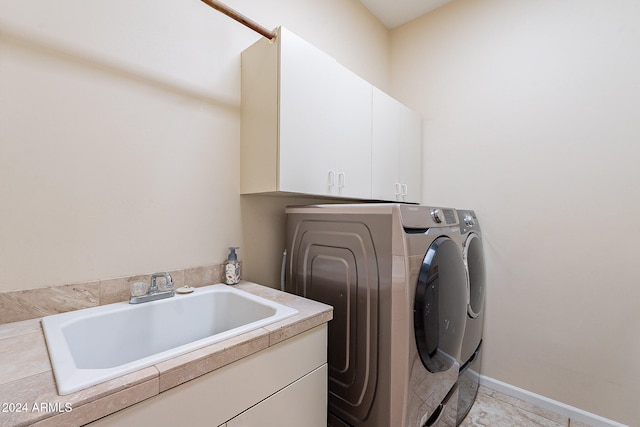 laundry area with cabinets, sink, and washer and clothes dryer