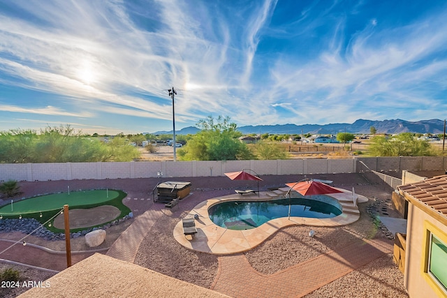 view of pool featuring a patio, a mountain view, and a hot tub