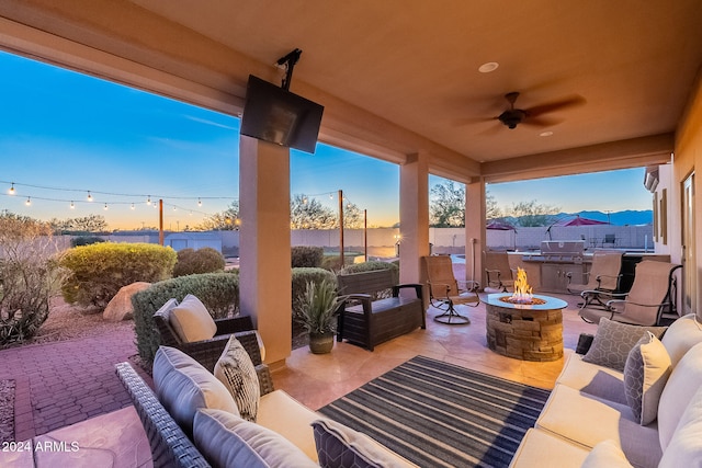 view of patio with an outdoor living space with a fire pit and ceiling fan