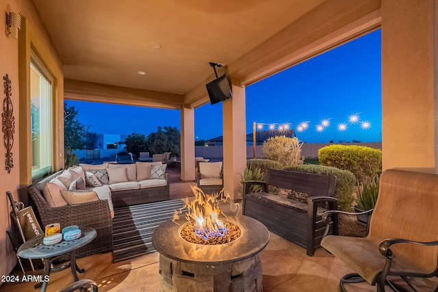 view of patio with an outdoor living space with a fire pit