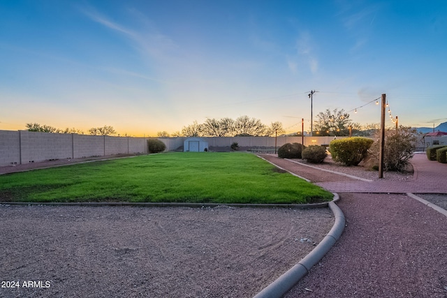 yard at dusk with a storage shed