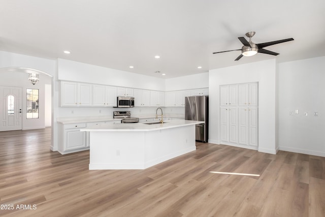 kitchen featuring white cabinetry, sink, an island with sink, ceiling fan with notable chandelier, and appliances with stainless steel finishes