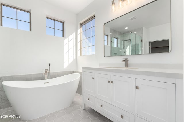 bathroom featuring tile patterned floors, vanity, and shower with separate bathtub