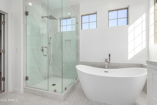 bathroom featuring tile patterned flooring, vanity, and shower with separate bathtub