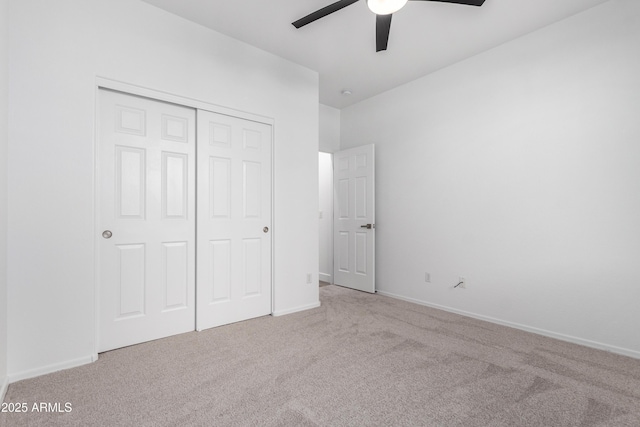 unfurnished bedroom featuring light carpet, a closet, and ceiling fan