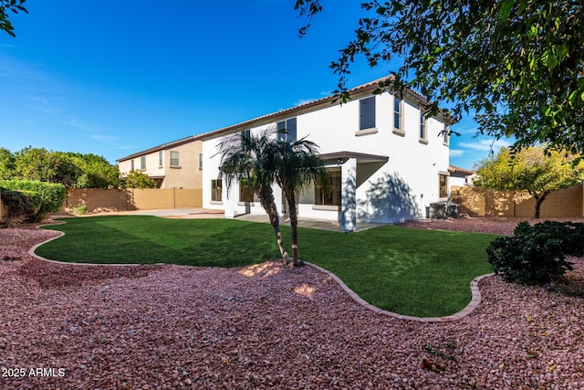 back of house featuring central AC, a patio area, and a lawn