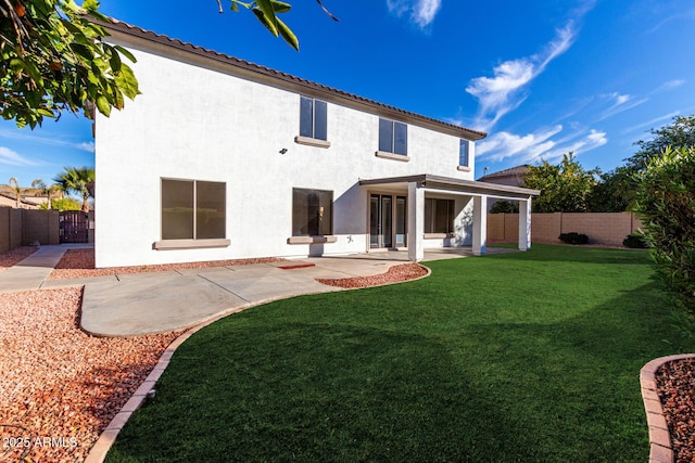 back of property featuring a patio and a lawn