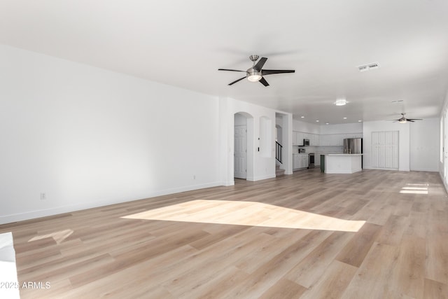 unfurnished living room with ceiling fan and light wood-type flooring