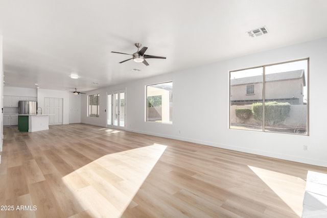 unfurnished living room with ceiling fan, light hardwood / wood-style floors, and sink