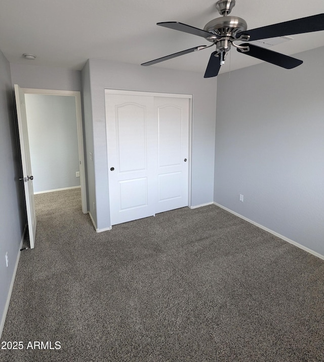 15446 W Jenan Dr, Surprise, AZ 85379 - unfurnished bedroom featuring a closet, dark colored carpet, baseboards, and a ceiling fan