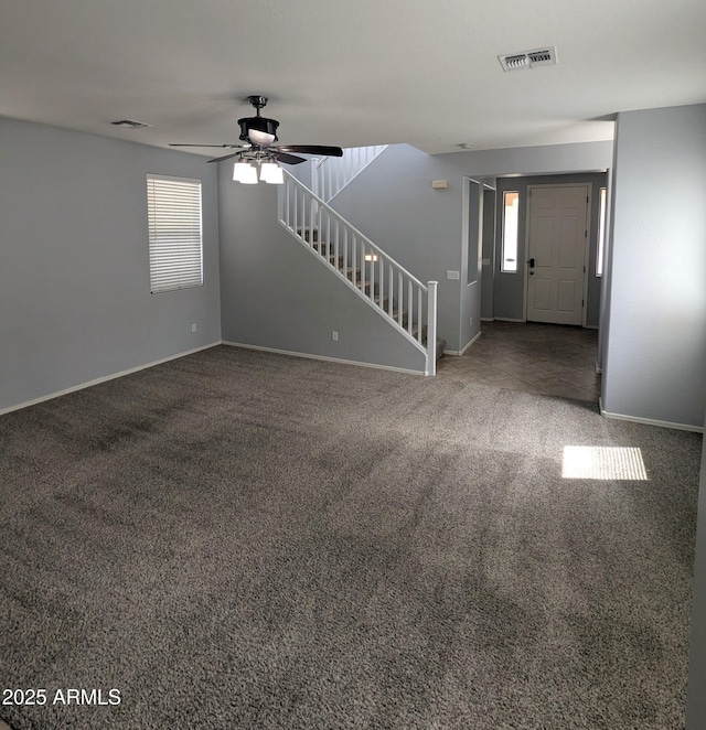 15446 W Jenan Dr, Surprise, AZ 85379 - unfurnished living room with healthy amount of natural light, stairs, carpet, and a ceiling fan