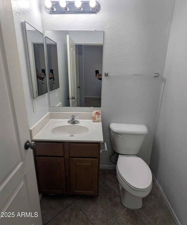 15446 W Jenan Dr, Surprise, AZ 85379 - half bath with tile patterned floors, toilet, vanity, and baseboards