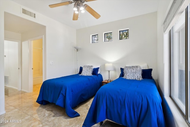 tiled bedroom with ensuite bath and ceiling fan