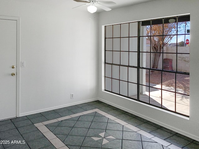 tiled empty room featuring ceiling fan