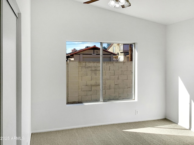 carpeted spare room with ceiling fan