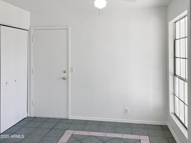 tiled spare room with ceiling fan